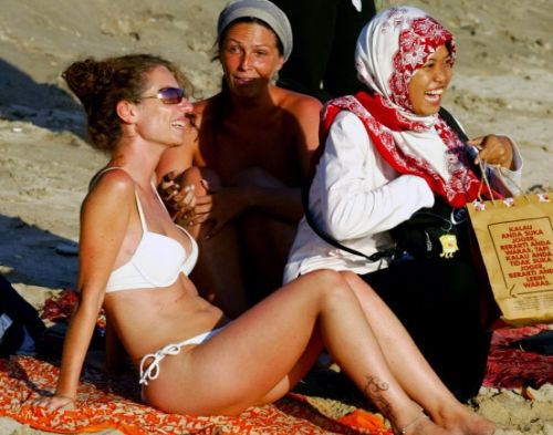 Eine Muslimin mit Kopftuch lässt sich in Indonesien mit einer Glaubenschwester im Bikini fotografieren